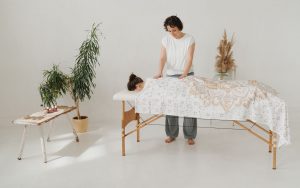 Doreen alias Ellie Lieb legt ihre Hände sanft auf den Rücken einer entspannten Klientin bei einer mobilen Massage zu Hause in Leipzig